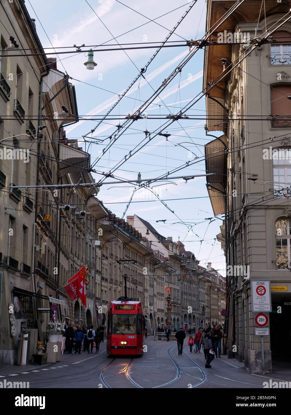 Traditional red tram in the Old City of Bern at dusk. Stock Photo