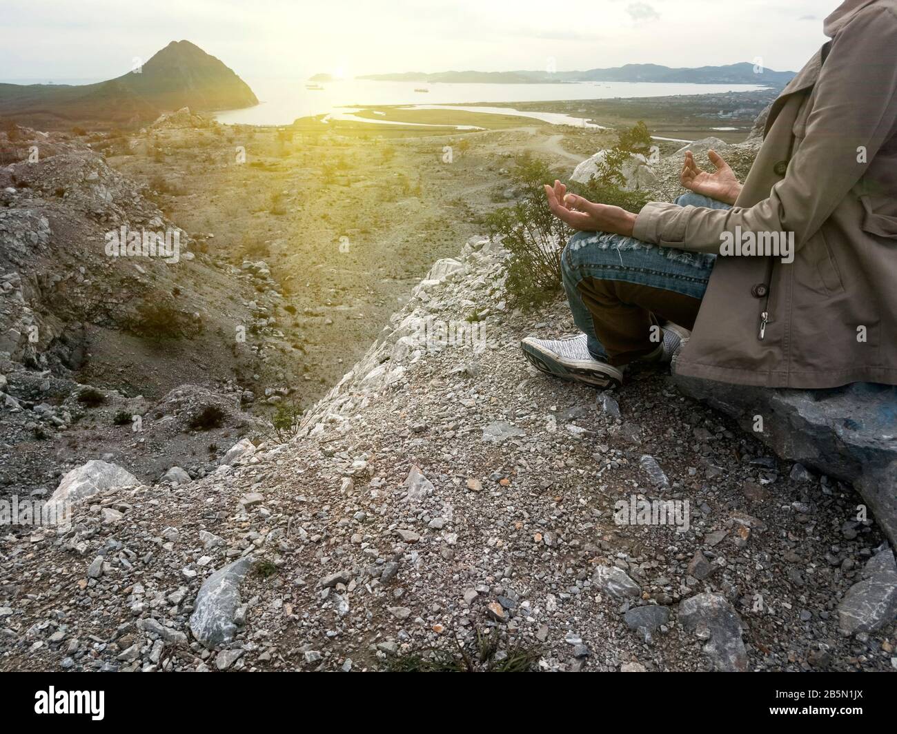 Yoga woman. Yoga poses. woman traveler sitting in lotus position meditating during sunset. Stock Photo