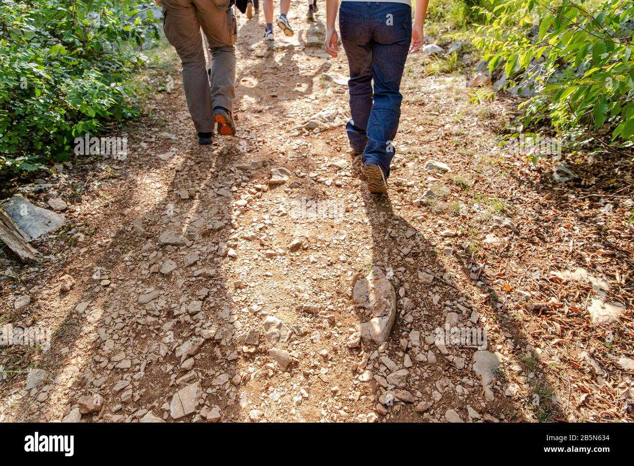 Legs and feet of a small group of people walking/hiking up a stone path.  Grabovaca, Lika and Senj County, Croatia Stock Photo