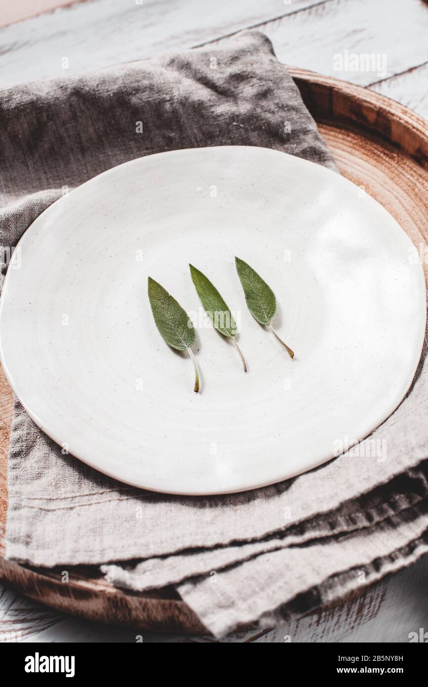 Minimalistic stock photo of sage leaves on white plate stock photo Stock Photo