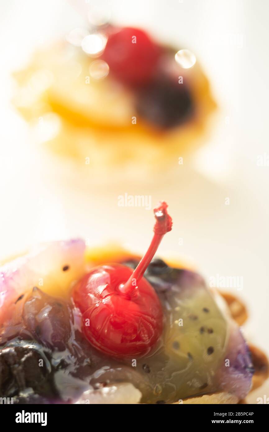 Sweet cake basket with fruits and red cherry closeup. Stock Photo