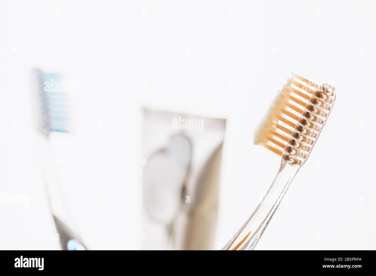 Two plastic toothbrushes and toothpaste on white background. Stock Photo