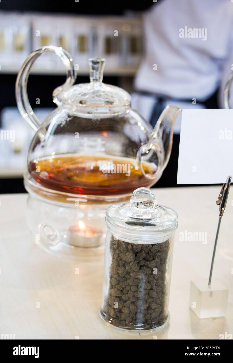 Herbal tea brewed in glass teapot and tea plant in a bottle Stock Photo