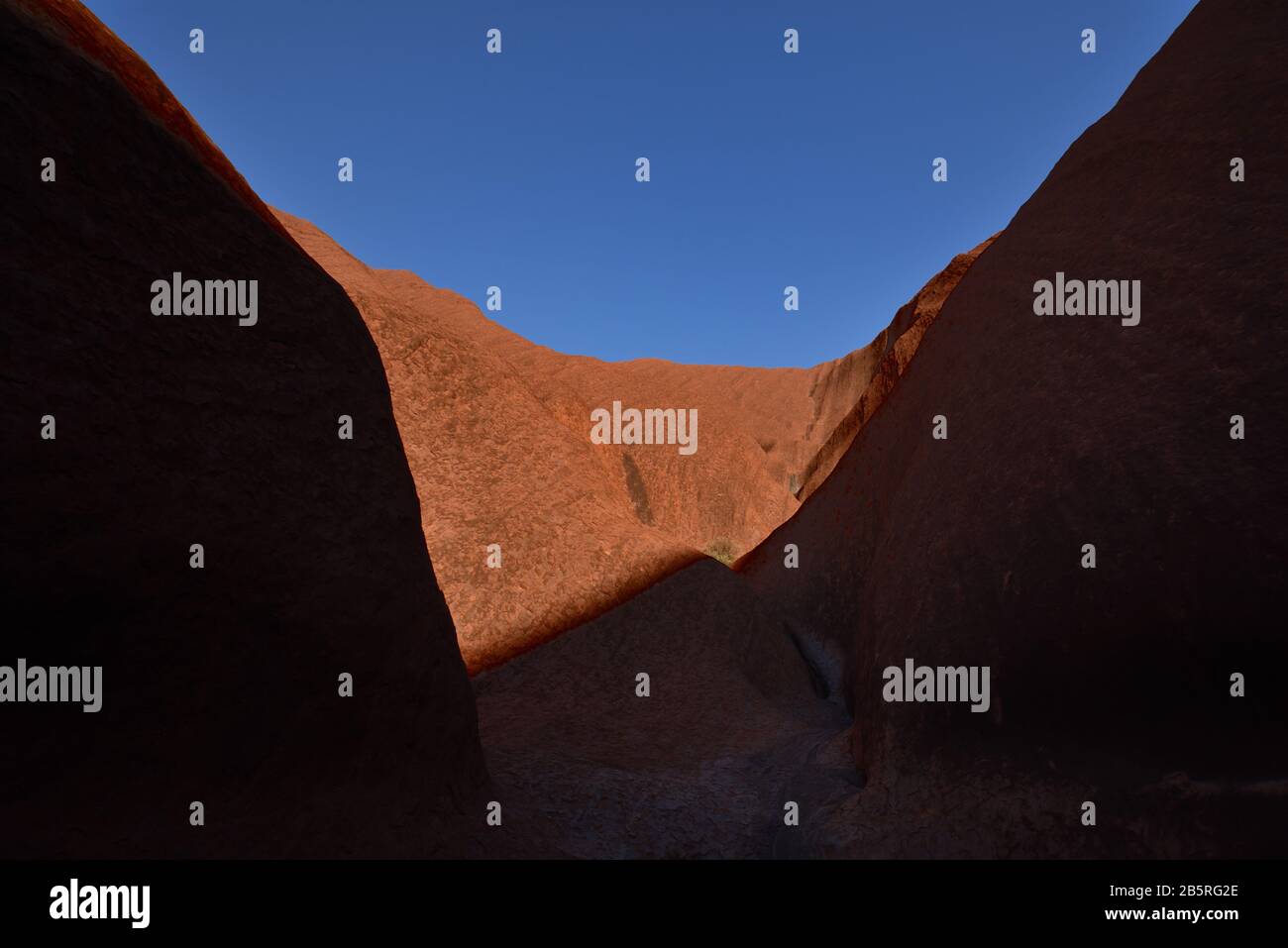 Uluru Ridges Light & shadow across Mutitjulu Waterhole Uluru, rockface, ridge & blue ...