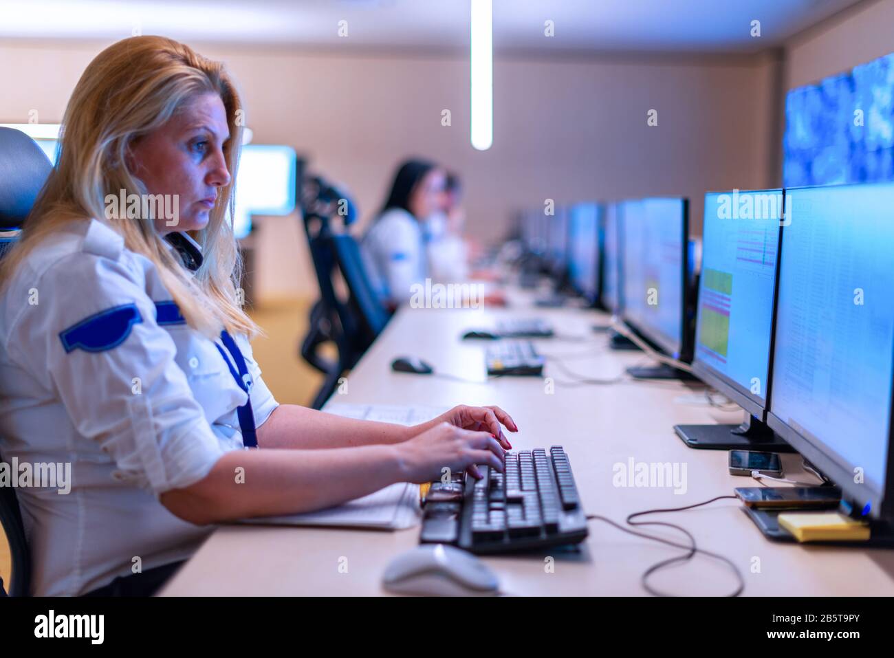 Female security operator working in a security data control room