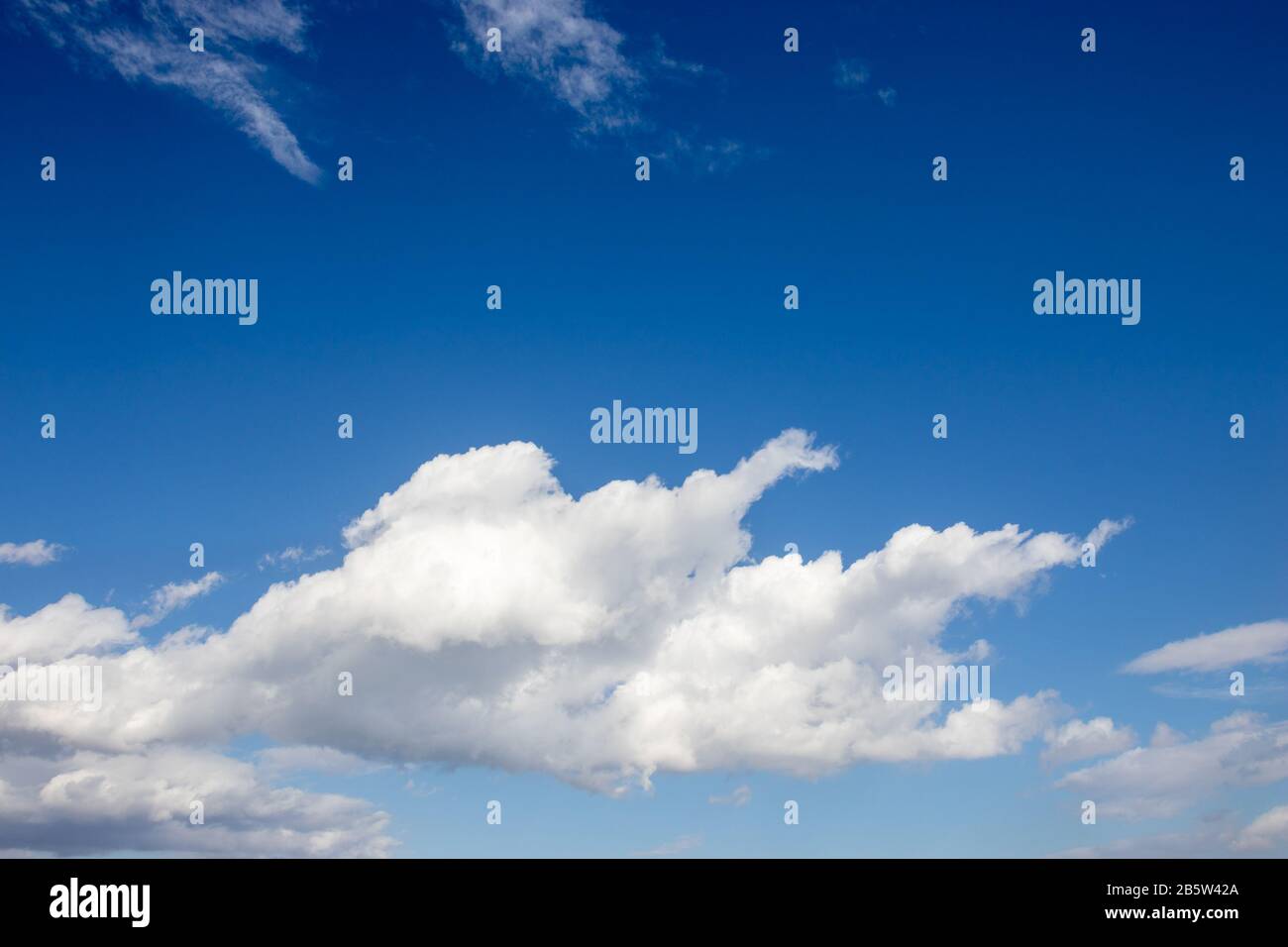 White fluffy clouds on bright blue sky Stock Photo