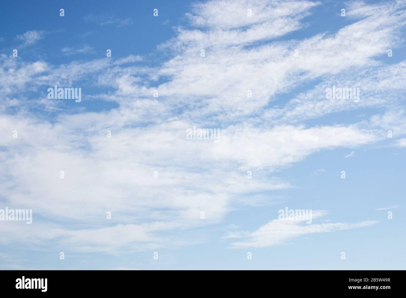 White fluffy clouds on bright blue sky Stock Photo