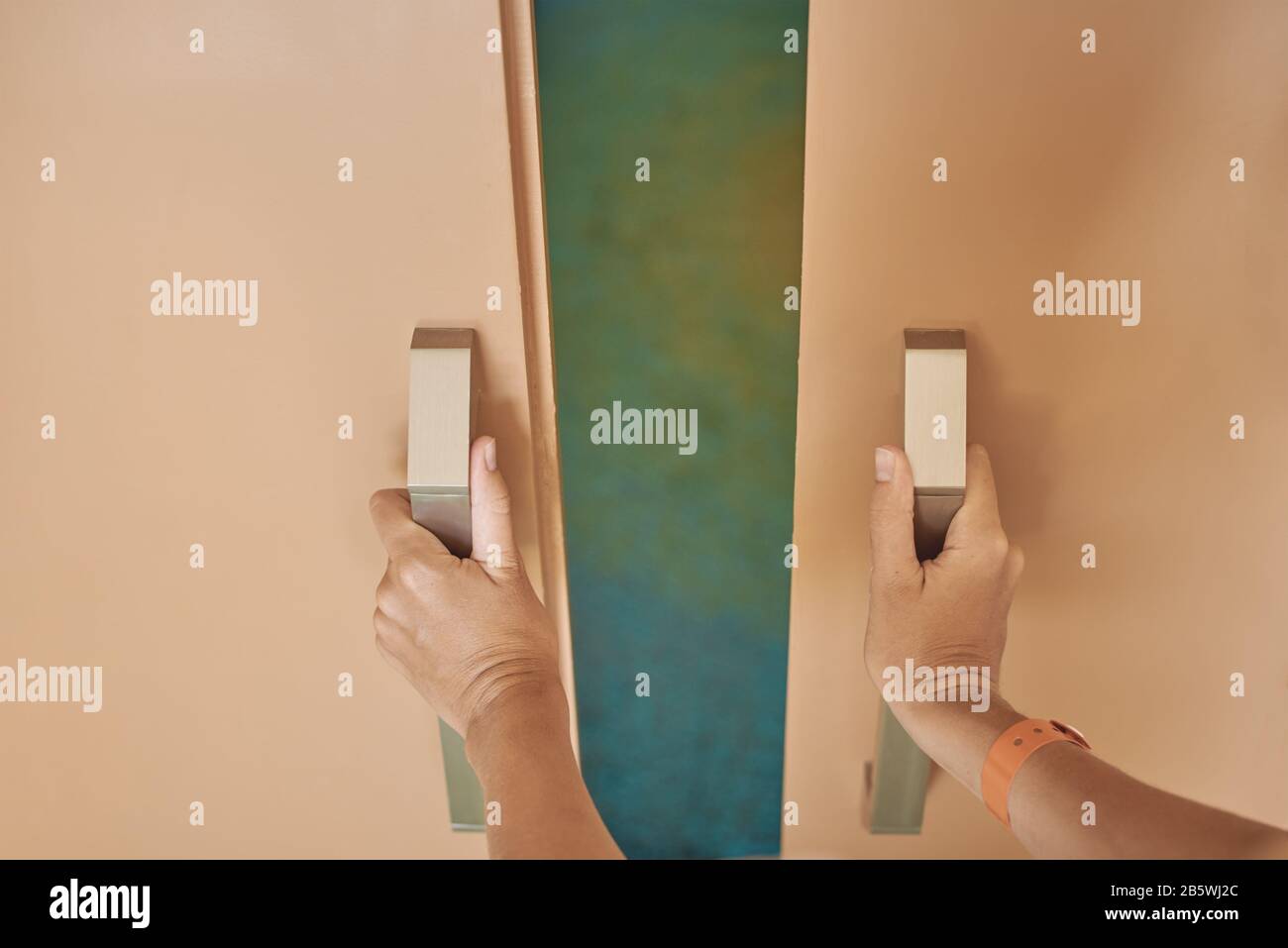 Hands open a sliding door in hotel room Stock Photo