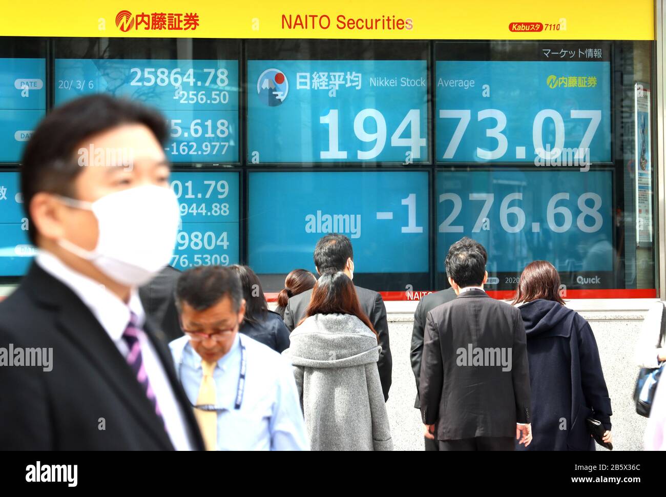 Tokyo, Japan. 9th Mar, 2020. Pedestrians pass before a share prices board in Tokyo on Monday, March 9, 2020. Japan's share prices fell 1,276.68 yen to close at 19,473.07 yen at the morning session of the Tokyo Stock Exchange for the fears of the global economic impact on the coronavirus outbreak. Credit: Yoshio Tsunoda/AFLO/Alamy Live News Stock Photo
