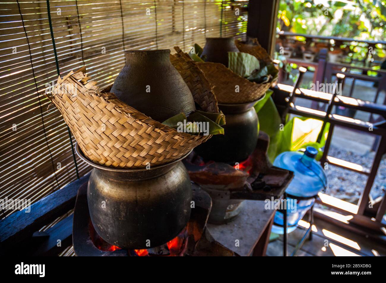 Sticky rice steaming in bamboo baskets over a taoloh at the