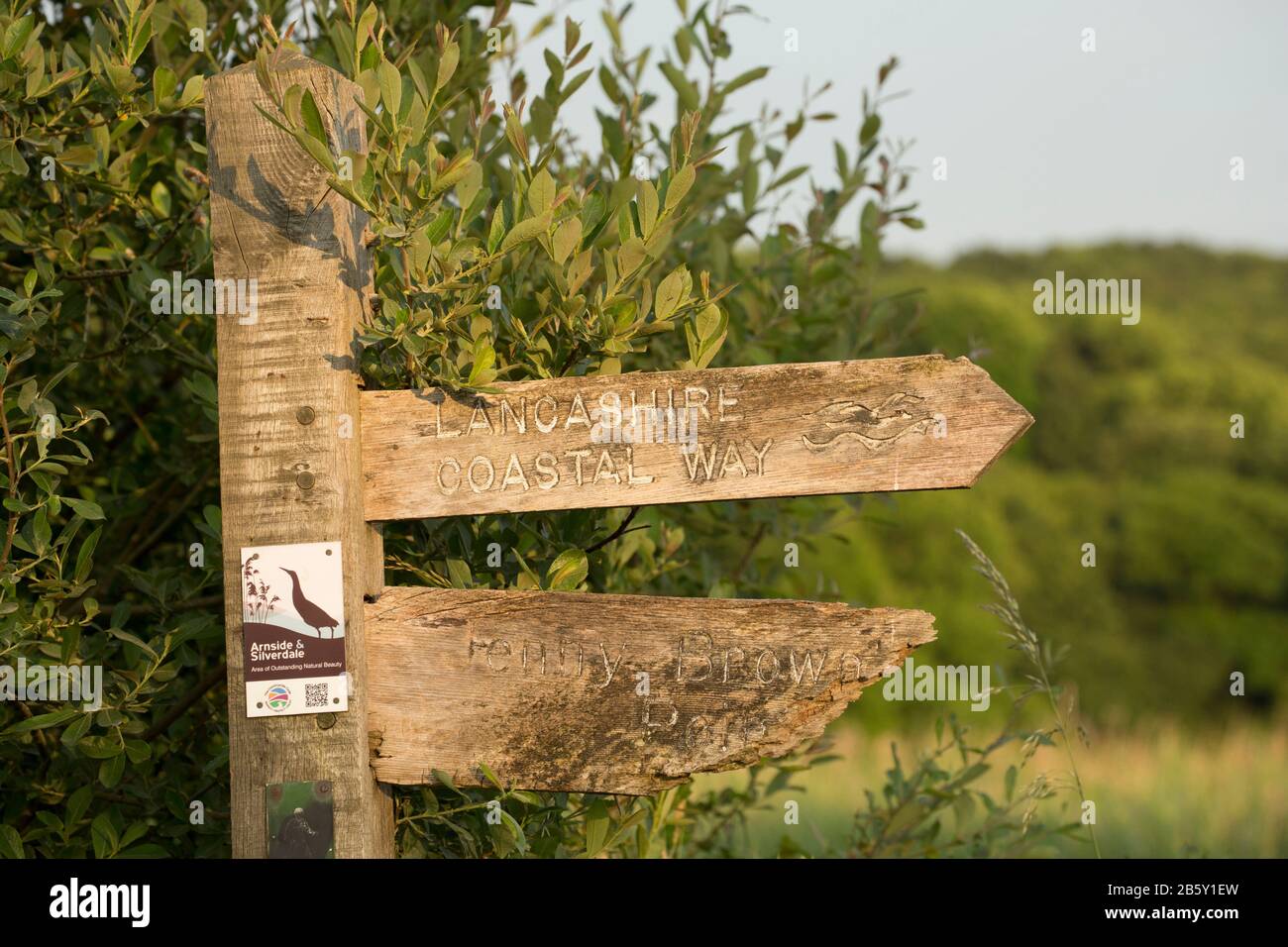 A wooden finger sign  on the edge of saltmarshes indicating the Lancashire Coastal Way near Jenny Brown’s Point not far from the village of Silverdale Stock Photo