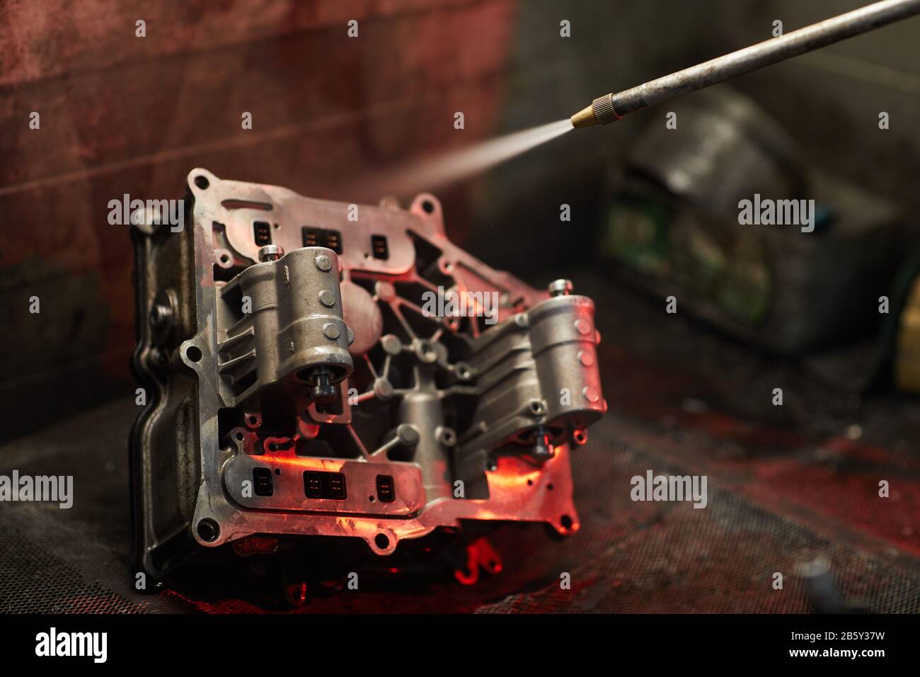 Using sandblast gun to clean dirty car engine part, horizontal close up shot, copy space Stock