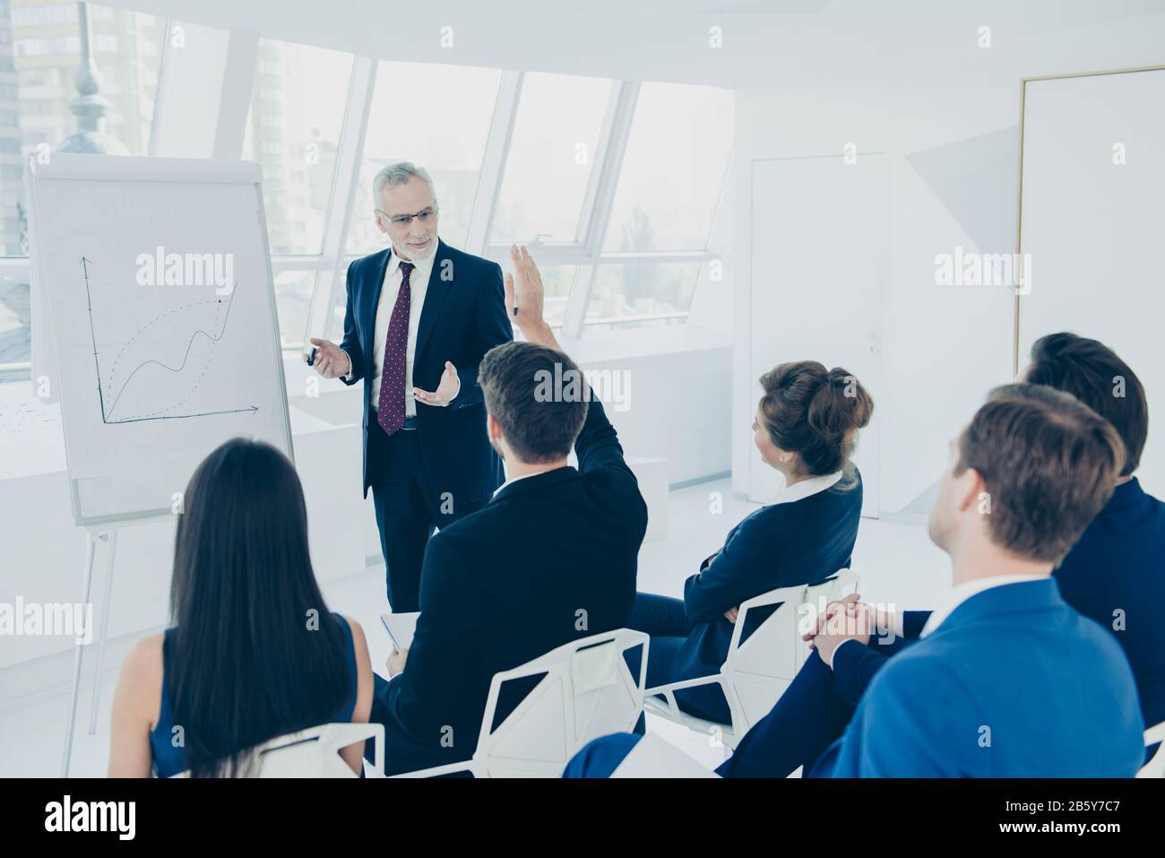 Successful aged businessman explaining the graph on the whiteboard in ...