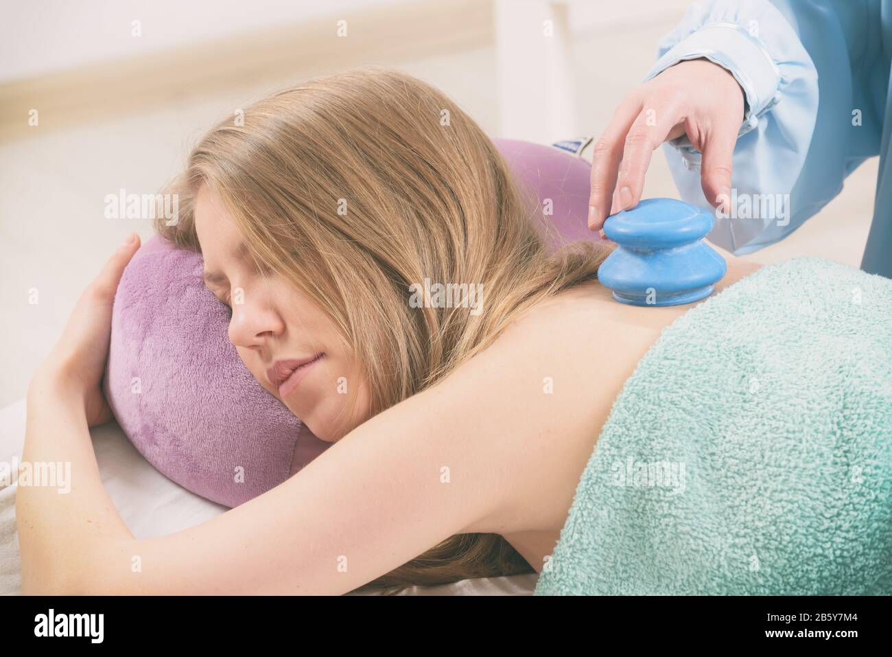 Therapist doing traditional chinese cupping therapy on her patient