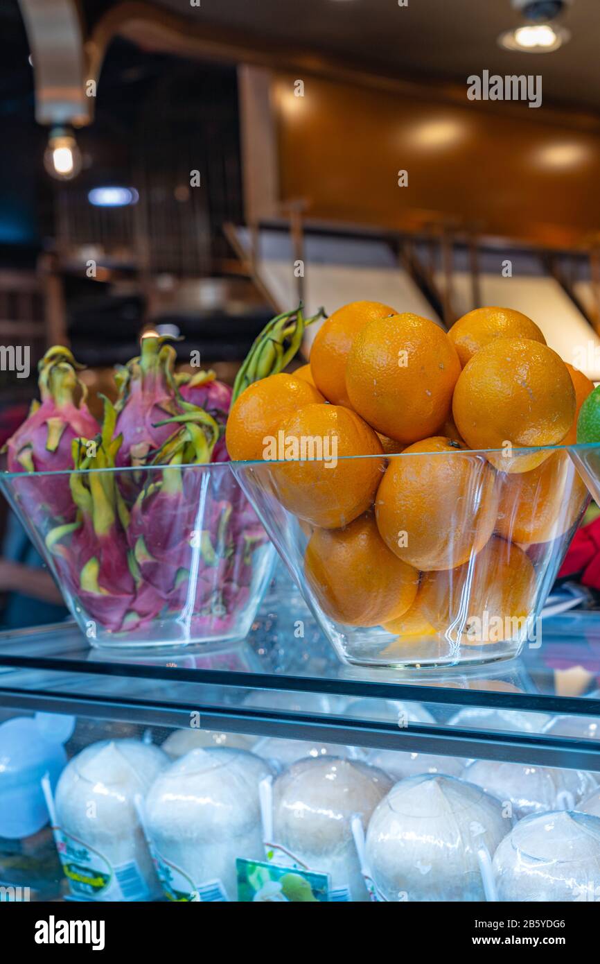 Fresh oranges and dragon fruits displayed at juice store Stock Photo