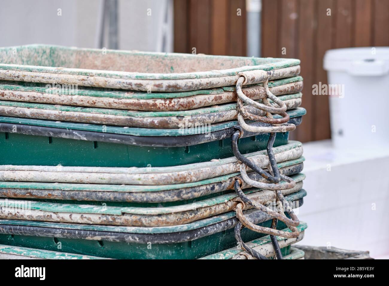 Close-up of a stack of dirty rectangular mortar buckets on a building site. Seen in Germany in February Stock Photo