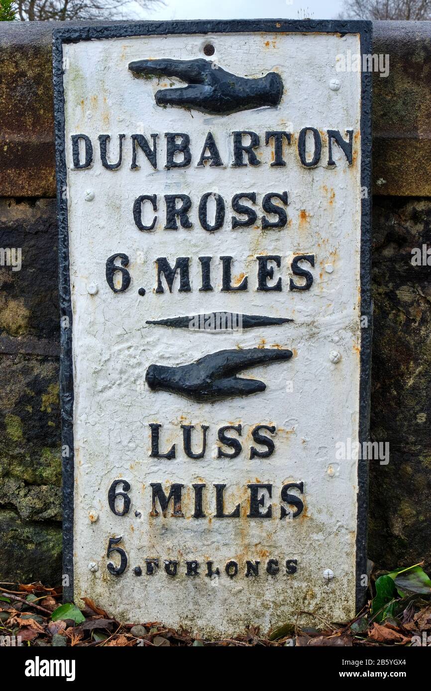 Traditional mile post at Duck Bay, pointing to Dunbarton Cross and Luss, near Loch Lomond, Balloch, Scotland Stock Photo