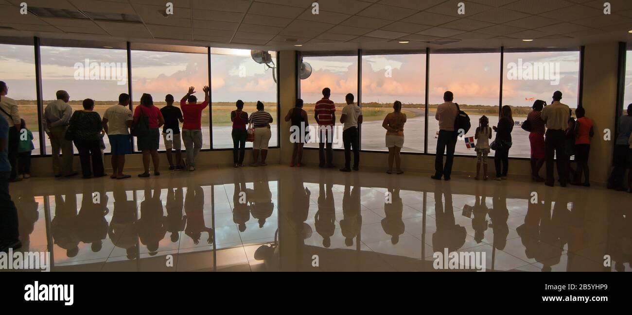 Santo Domingo, Dominican Republic - february 28, 2014 People in silhouette looking out of a window at an aeroplane departing Stock Photo