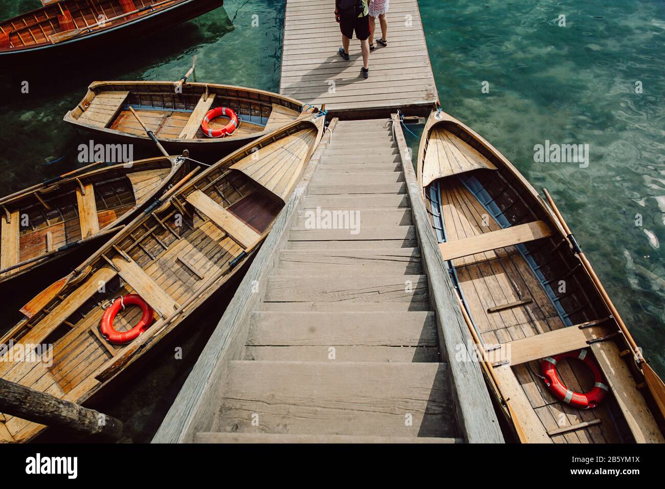 Wooden boats tied to a pier at a boat station on a lake in Italy, the ...