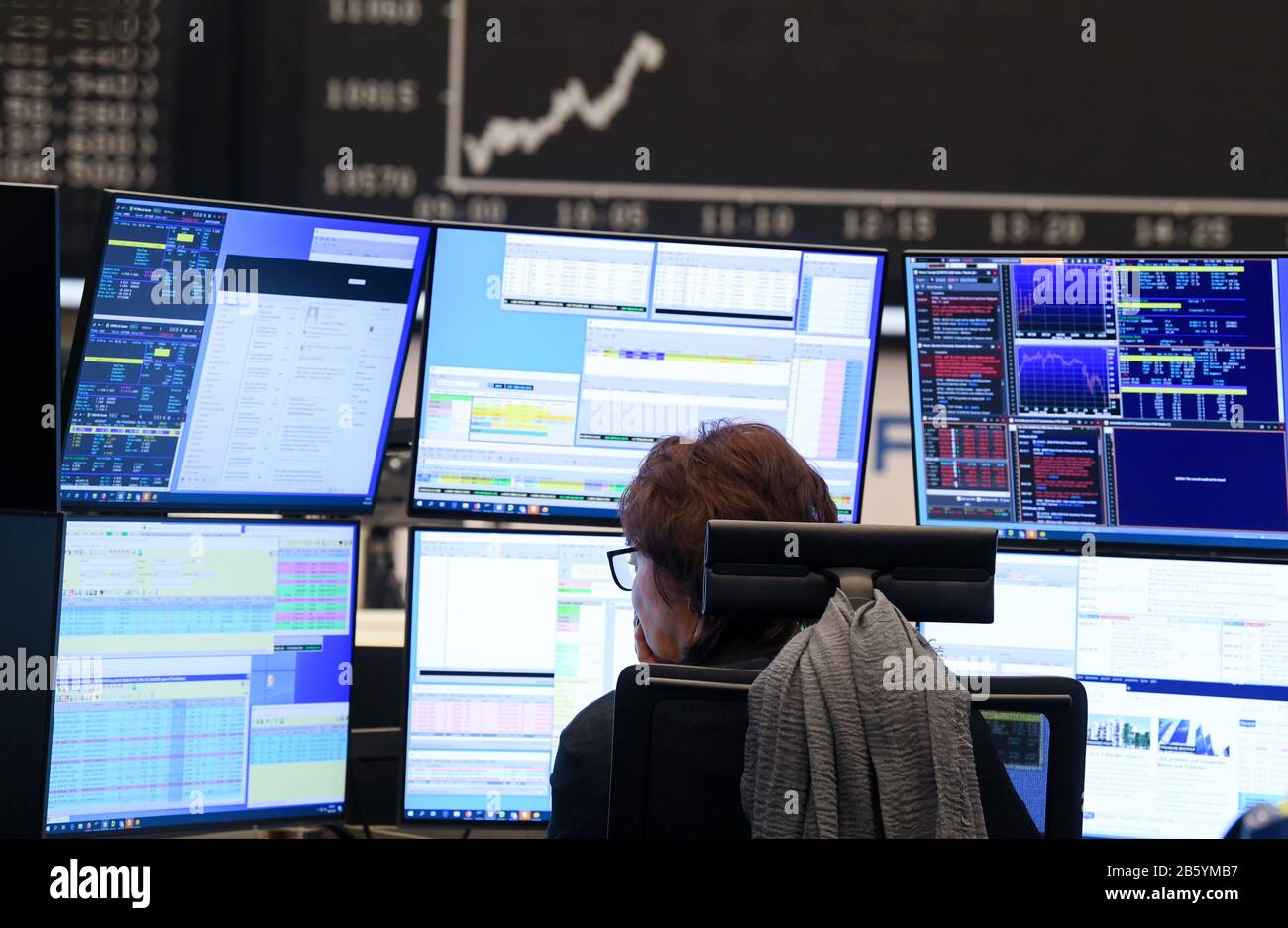 09 March 2020, Hessen, Frankfurt/Main: A stock trader watches her monitors on the trading floor of the Frankfurt Stock Exchange. Stock exchanges around the world are reacting with huge losses to the fall in oil prices and concerns about the economic consequences of the coronavirus epidemic. Photo: Arne Dedert/dpa Stock Photo