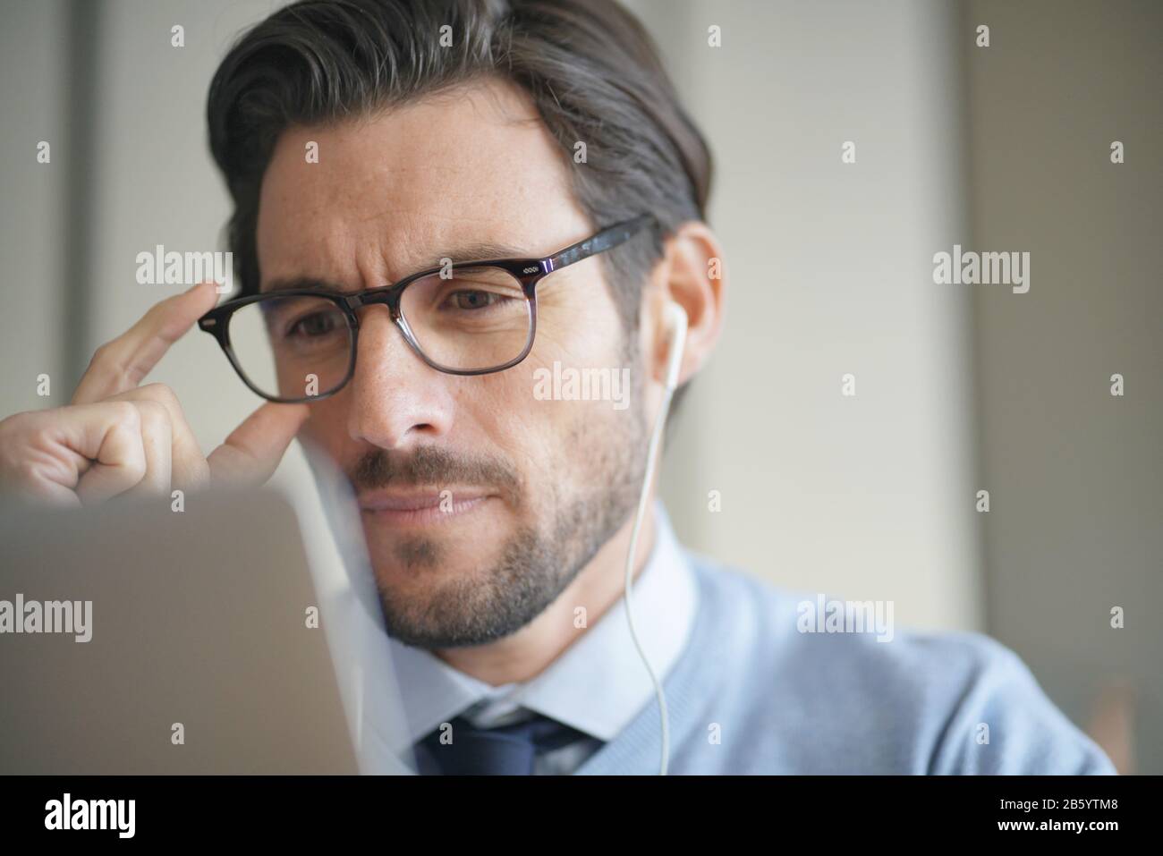 Portrait of attractive man working on laptop wearing glasses Stock Photo -  Alamy