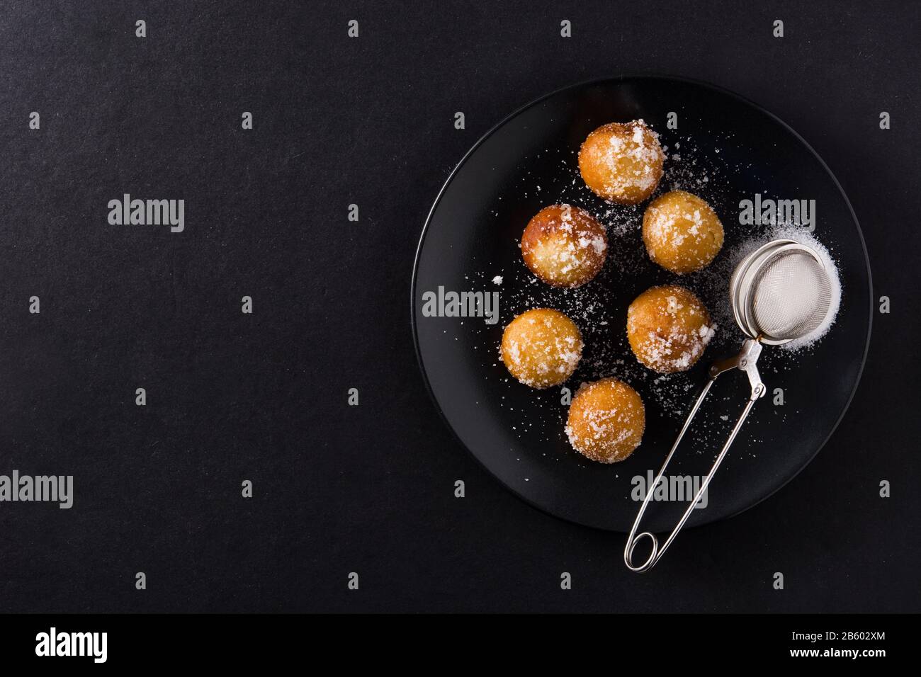 Carnival fritters or buñuelos de viento for holy week on black background. Top view copy space Stock Photo