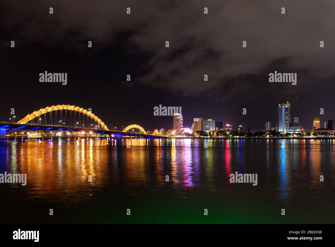 Night scene of Han river, illuminated Dragon bridge and buildings in DaNang city, Vietnam Stock Photo