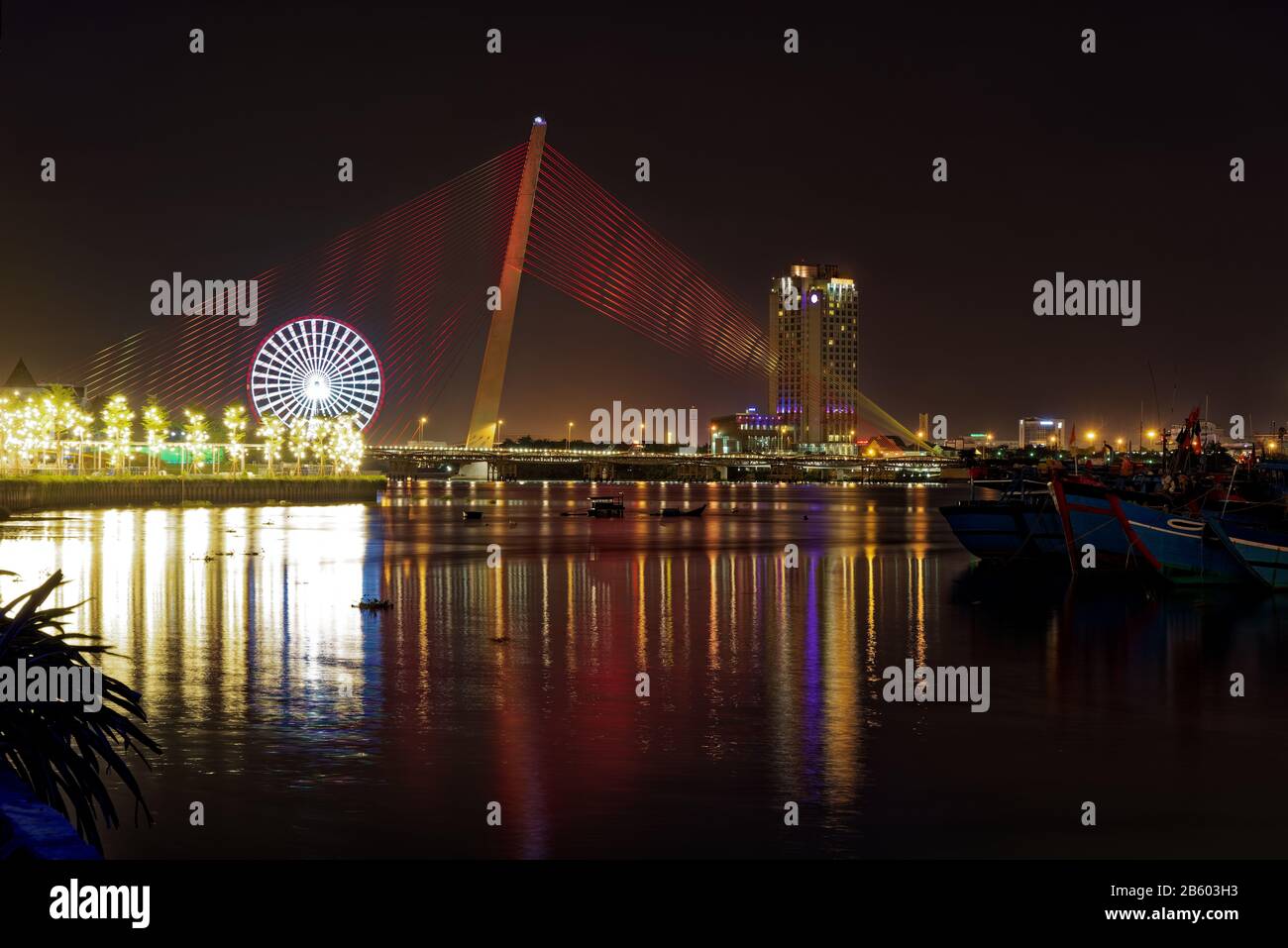 Illuminated Tran Thi Ly Bridge at night. Cable-stayed bridge spans the Han River in the city of Da Nang, Vietnam Stock Photo