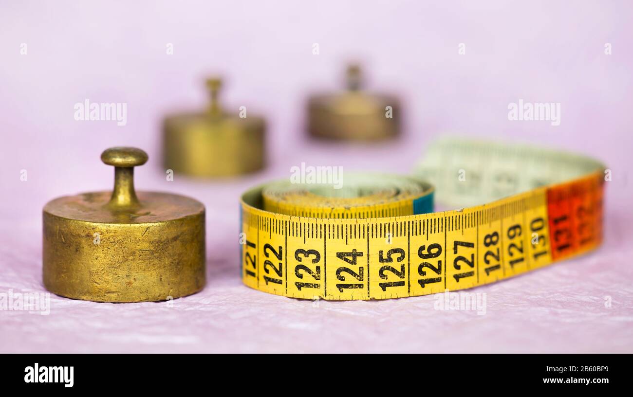Weight loss, diet concept, vintage retro copper weights and tape measure, web banner Stock Photo