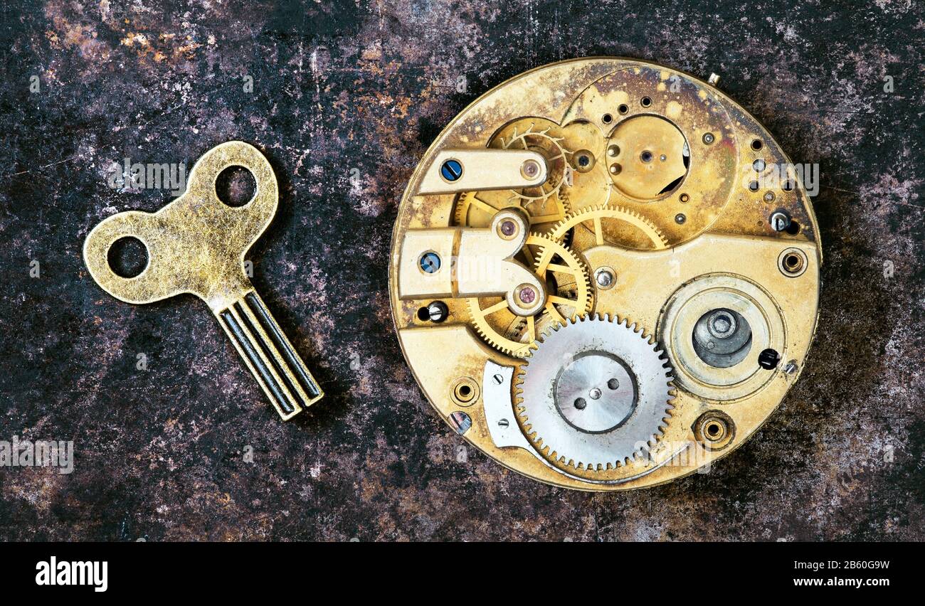 Vintage key and gold watch clockwork mechanism gears timing time management concept Stock Photo Alamy