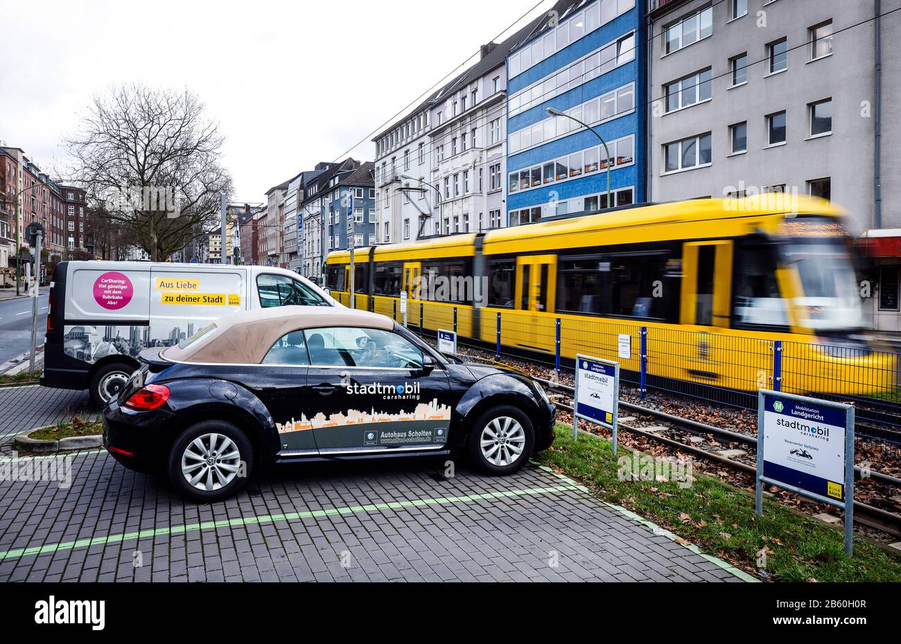 Essen, Ruhr area, North Rhine-Westphalia, Germany - A carsharing stadtmobil stands at the mobile station Landgericht, in the back a tram. Essen, Ruhrg Stock Photo