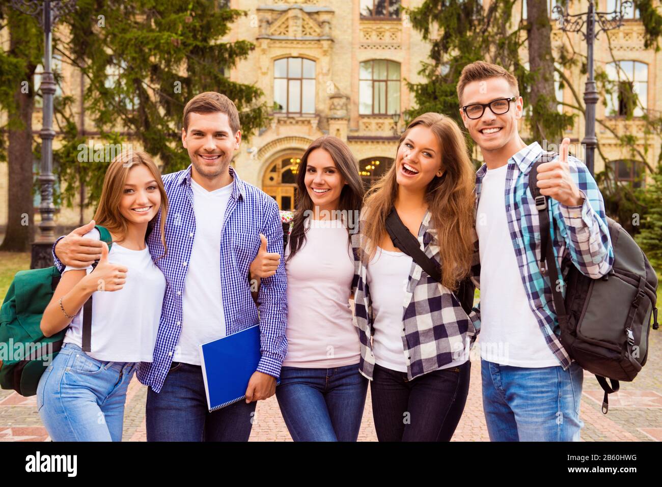Portrait of group of happy students showing thumbs up Stock Photo - Alamy