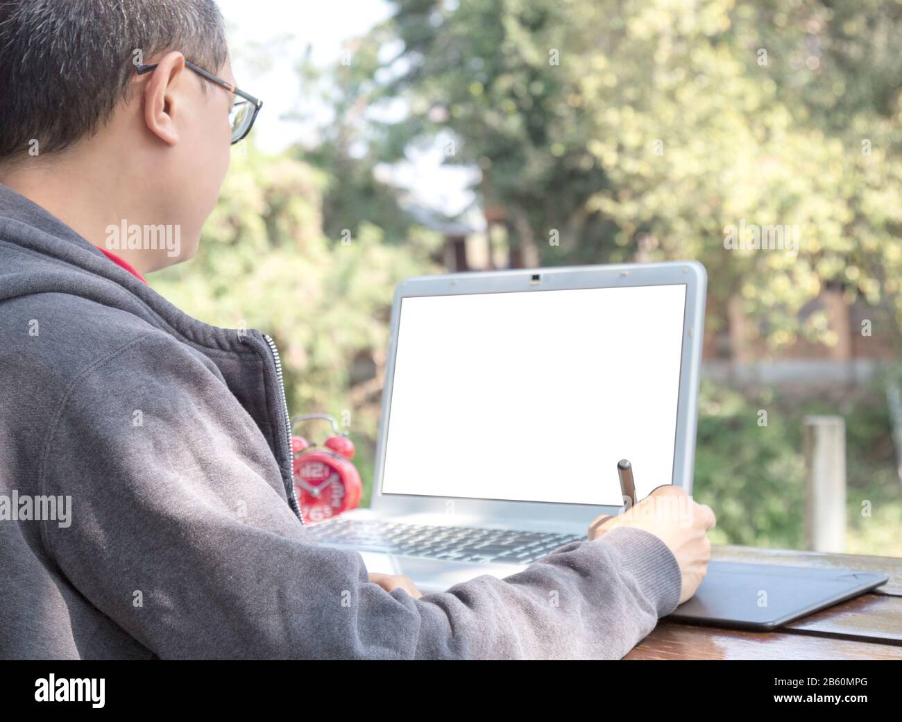 Asia middle age freelance working with mouse pen on laptop at outdoor restaurant or cafe. The blank screen with copy space for your text or advertisin Stock Photo