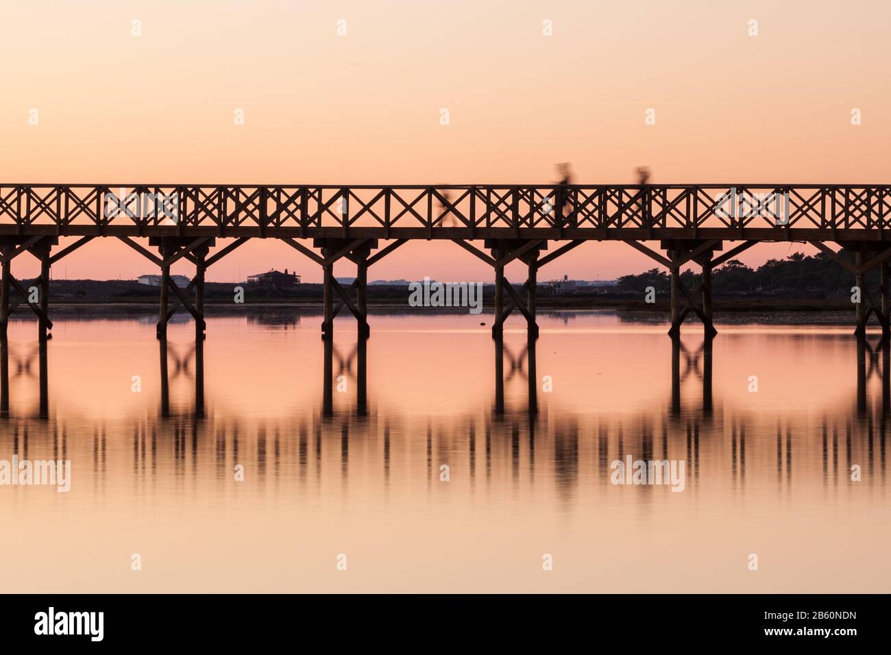 Wooden bridge at sunset with silhouettes of people. Quinta Lago Stock ...