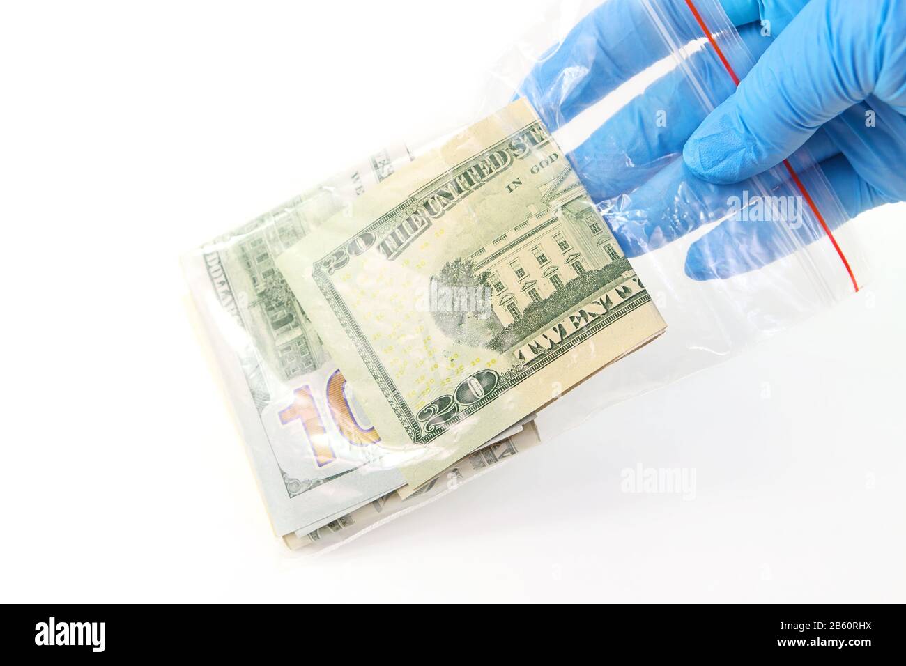 A hand in a medical glove holds a transparent plastic bag with money that is a source of infection Stock Photo