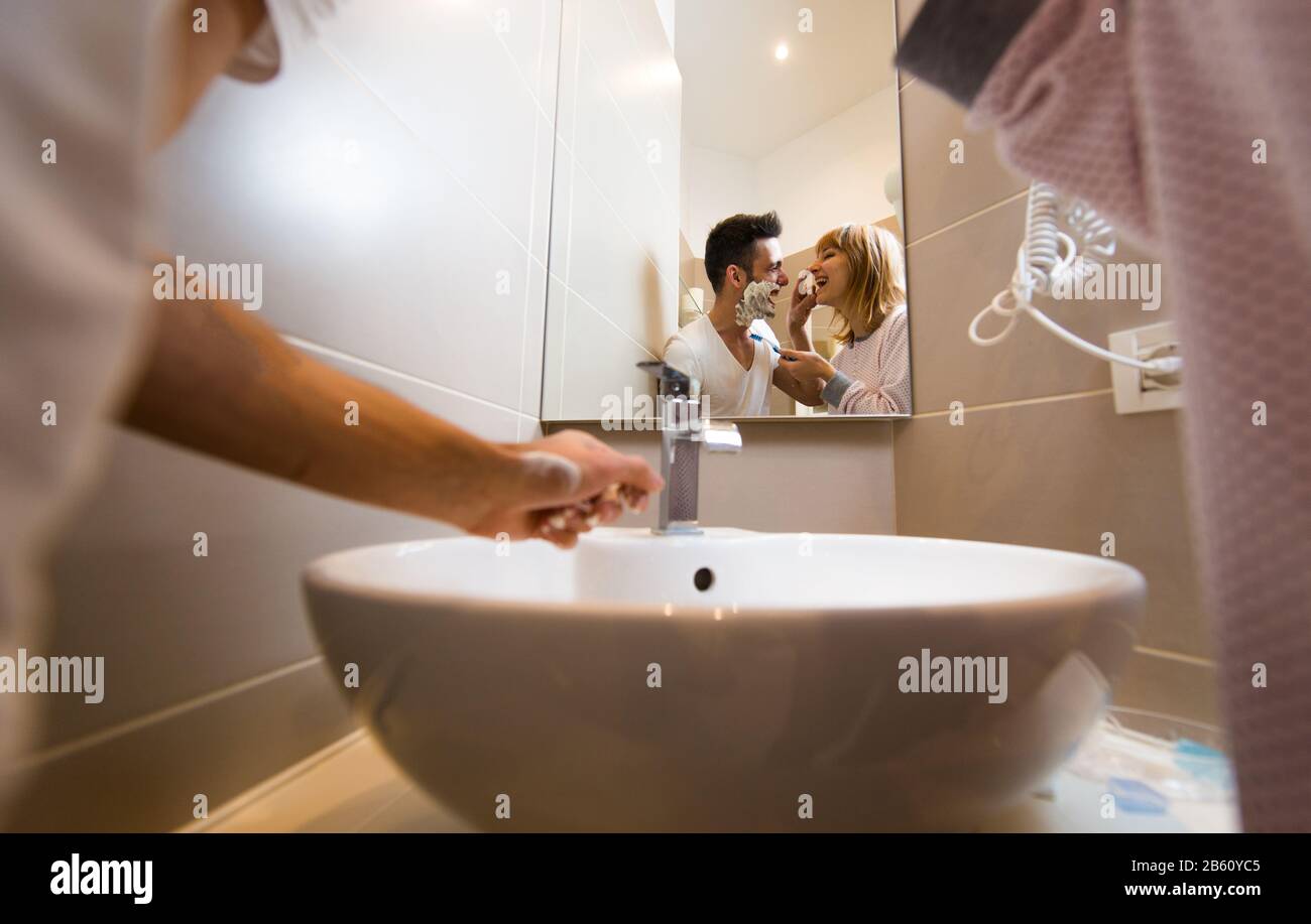 Two young adults at home - Beautiful couple having fun in the bathroom Stock Photo