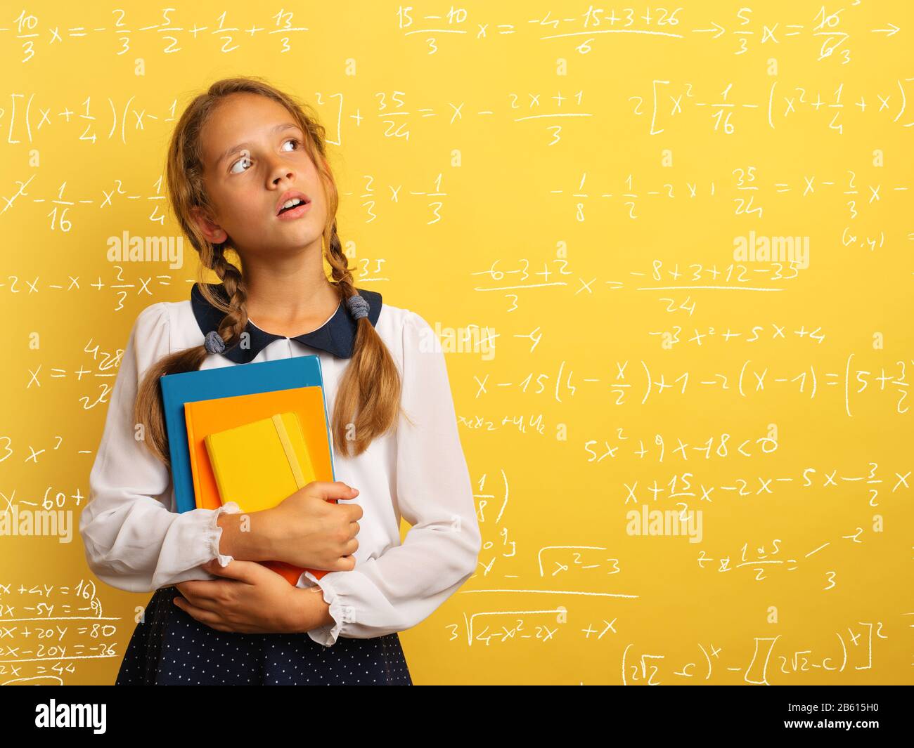 Young student is with shocked expression and think about complex exercises. Yellow background Stock Photo