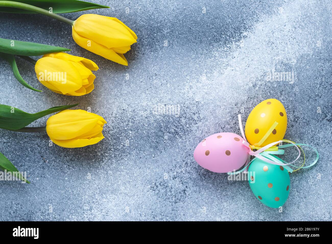 Easter eggs and yellow tulips on shabby blue and gray concrete ...