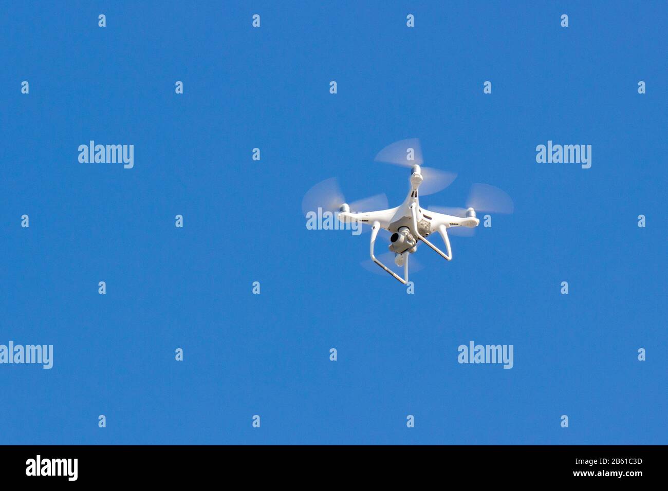 Quadcopter drone is flying in the blue sky. Unmanned aerial vehicle ...