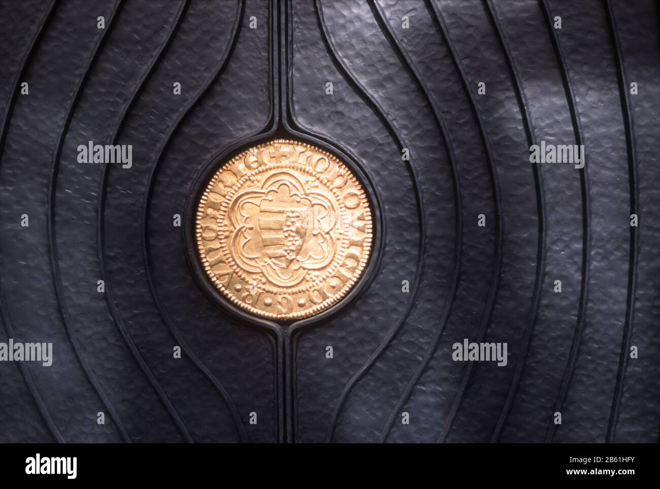 Gold medallion set in a fancy, black, metal door in Pecs, Hungary Stock Photo