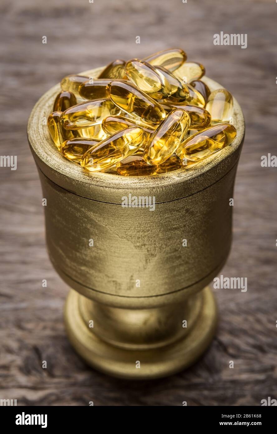 Golden Bowl with golden diet pills. Vitamin E. Stock Photo