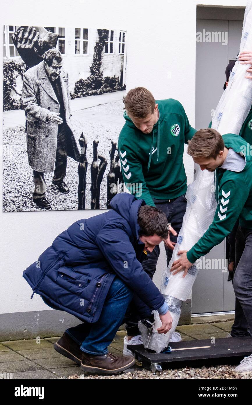 09 March 2020, Schleswig-Holstein, Lübeck: Jörg-Philip Thomsa, manager of the Günter Grass House (l-r), together with the footballers Lukas Raeder and Morten Rüdiger from VfB Lübeck, will set up an original goal from the football World Cup semi-final match between Germany and Brazil in 2014 (1:7) in the courtyard of the Günter Grass House. The goal will be on display alongside other exhibits from 16 March in the exhibition 'Günter Grass: My Football Century'. Photo: Frank Molter/dpa Stock Photo