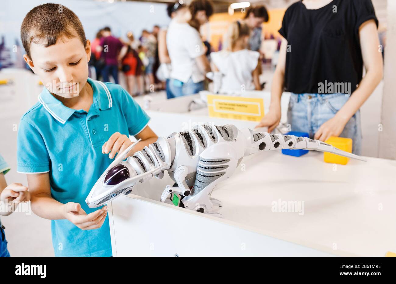 Kid boy playing with interactive robot toy at the exhibition Stock Photo