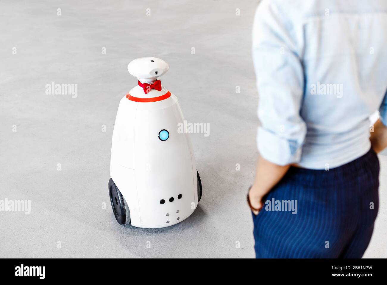 Robot receptionist talking to a woman, the concept of a robotic staff of the future Stock Photo