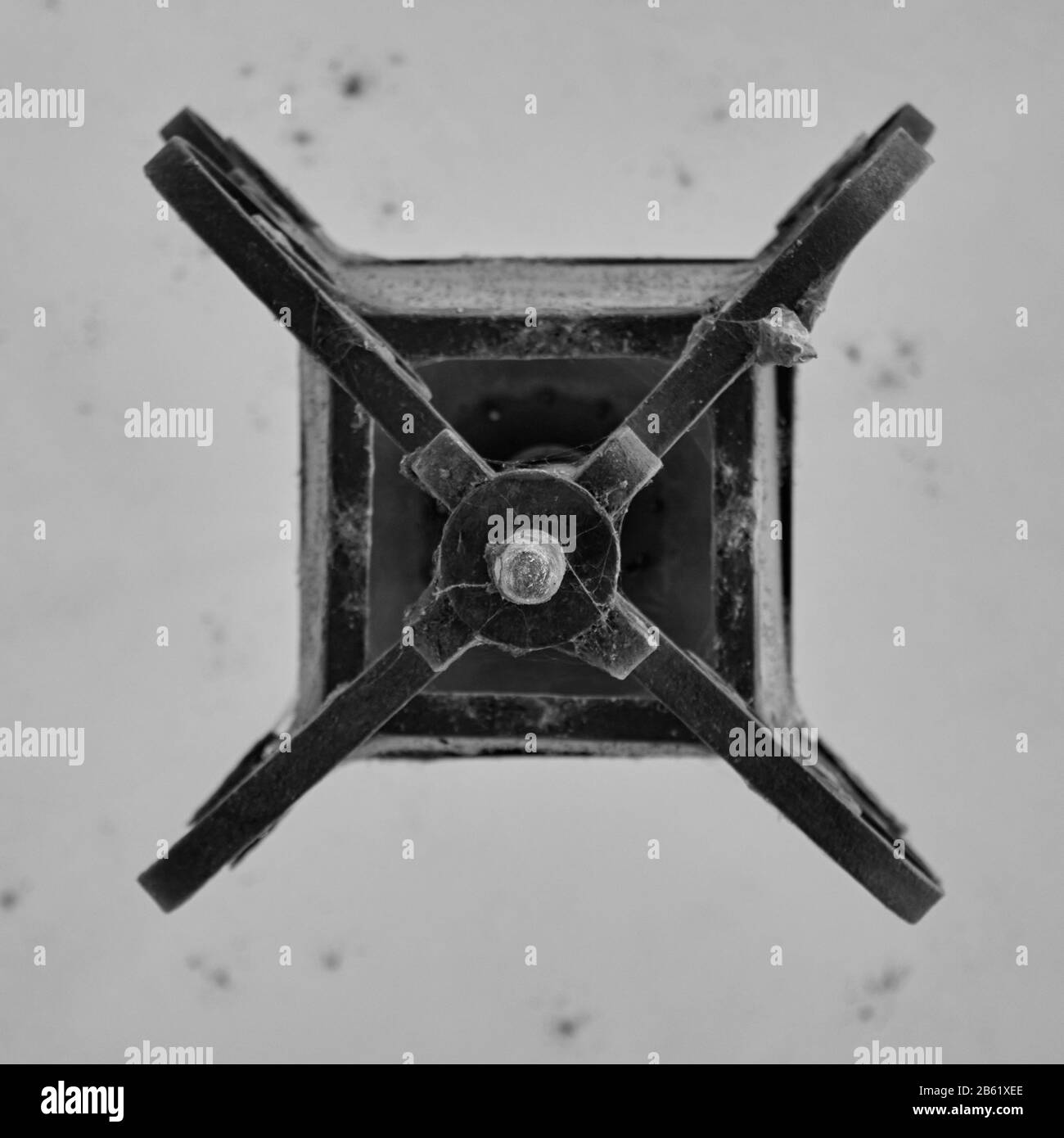 black and white detail of the bottom of old metal forged ceiling lantern Stock Photo