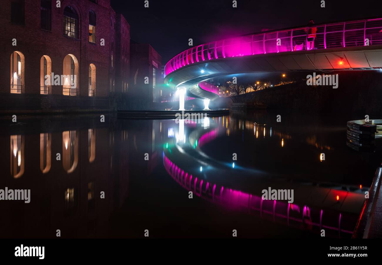 Bristol, England, UK - March 1, 2020: Pedestrians cross Bristol's Castle Bridge, shrounded in the fog of 'Pink Enchantment', one of the art installati Stock Photo