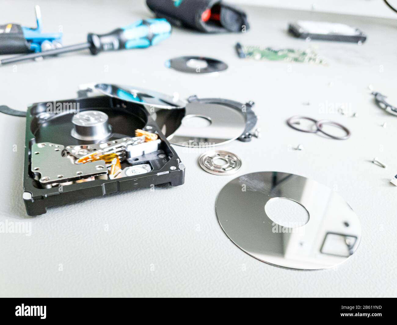 Opened computer hard drive on a table prepared to be fixed. Stock Photo