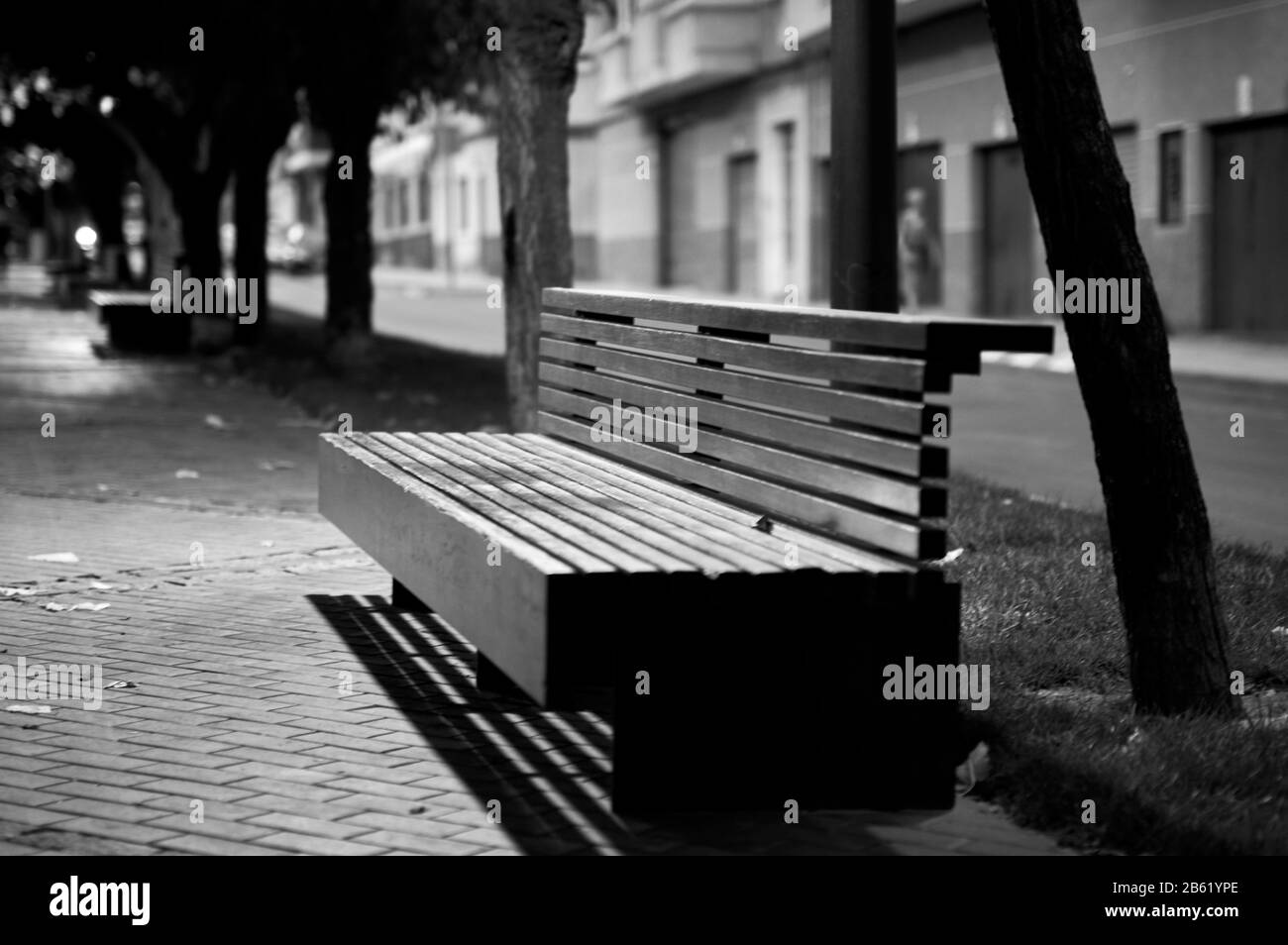 detail of a wooden bench on a walk in a street in winter in black and white Stock Photo