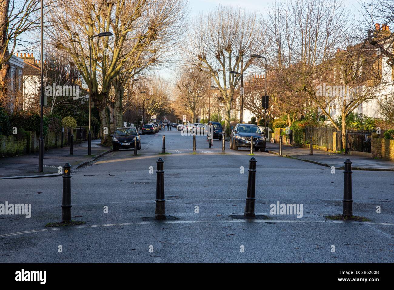 London, England, UK - January 17, 2020: Cyclists ride along residential streets that make up the Quietway 2 cycleway route in Hackney, past bollards t Stock Photo