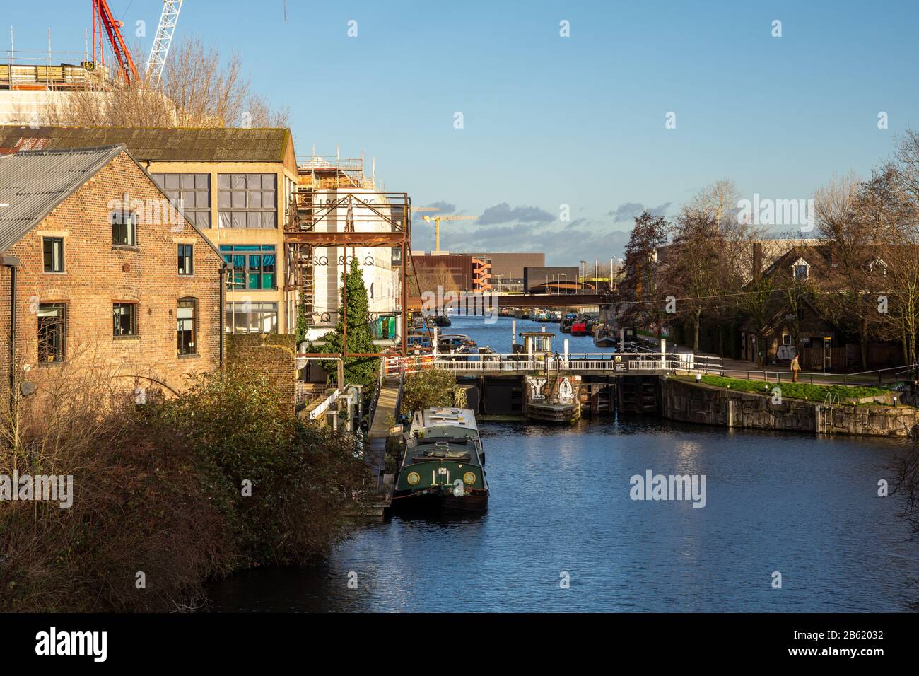 London, England, UK - January 9, 2020: Narrowboats are moored in the River Lea Navigation at Old Ford Locks, beside the regenerating Fish Island and O Stock Photo